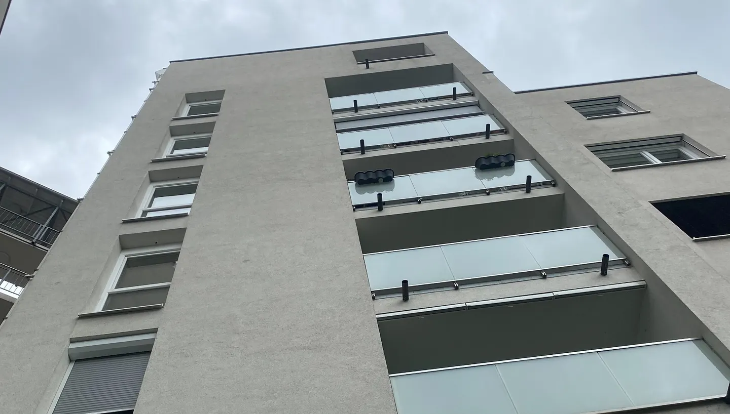 Mehrgeschoßiges Wohngebäude von unten gesehen.