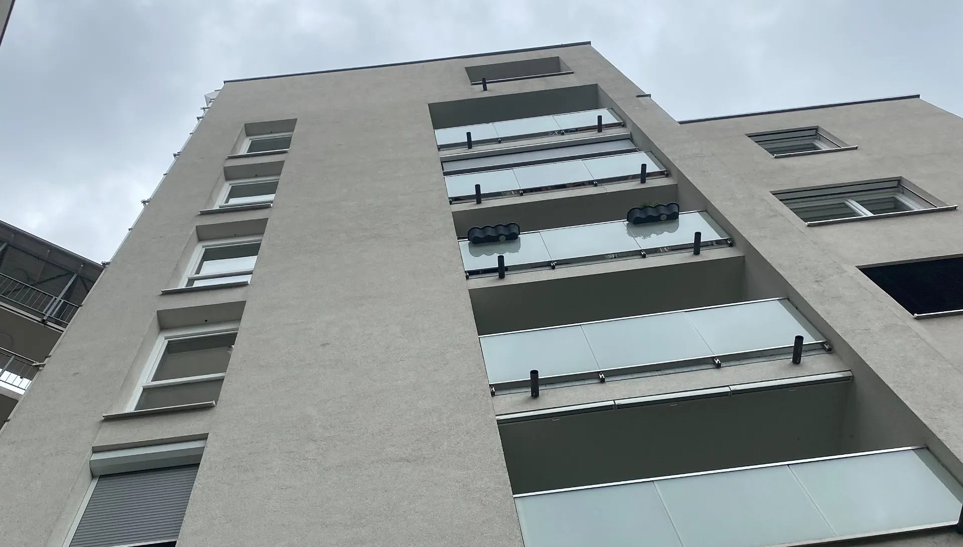 Mehrgeschoßiges Wohngebäude von unten gesehen.