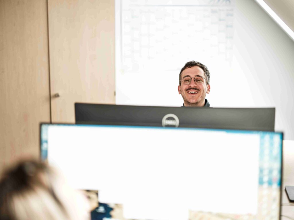 Zwei Experten der Themis Baumanagement GmbH bei der digitalen Projektberatung am Monitor in einem modernen Wiener Büro.