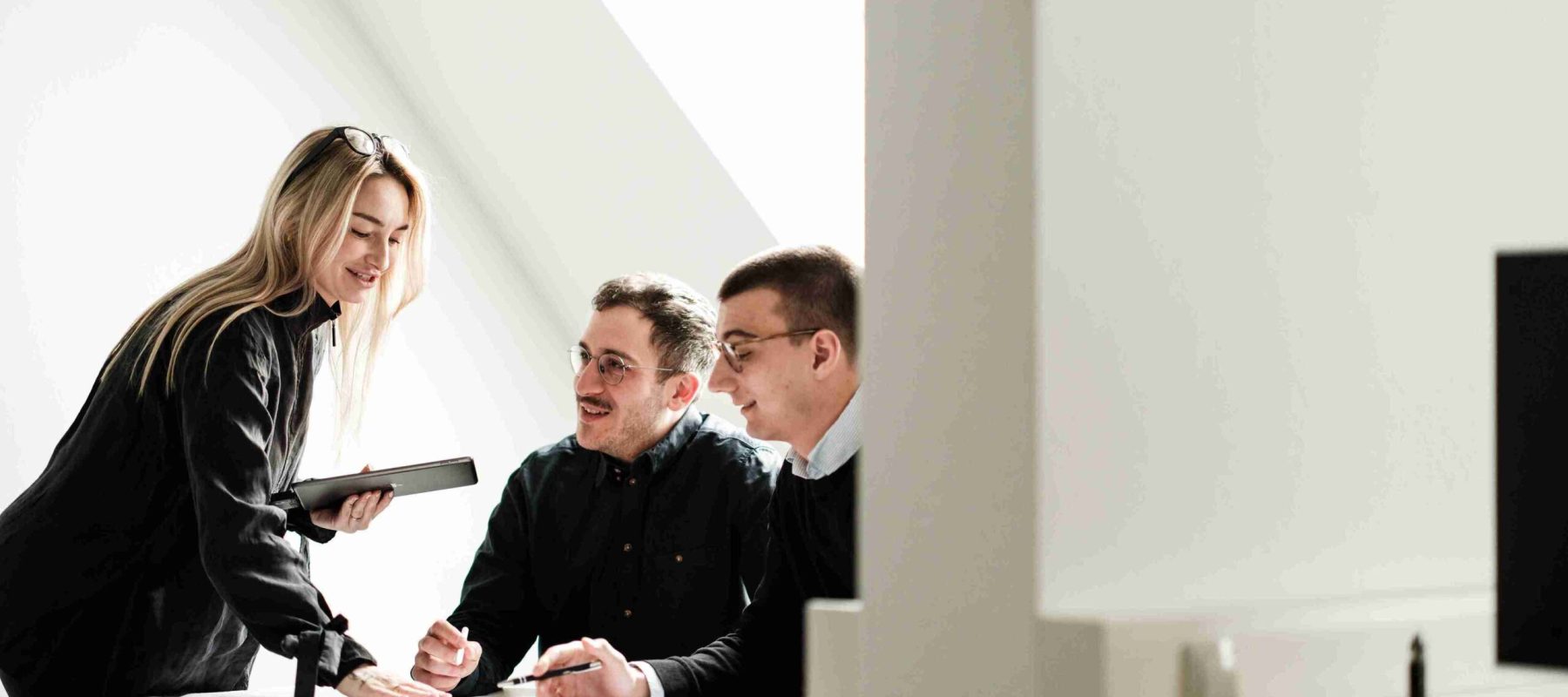 Drei Experten der Themis Baumanagement GmbH in einer gemeinsamen Fachberatung &uuml;ber Baupl&auml;nen in einem hellen B&uuml;ro.