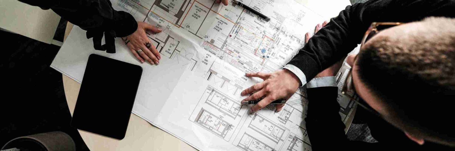 Die Experten der Themis Baumanagement pr&uuml;ft konzentriert technische Projektdokumente und Pl&auml;ne an ihrem Arbeitsplatz.